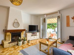 sala de estar con chimenea y TV en Holiday Home La Voie Romaine by Interhome, en Sauvian