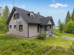 una casa con techo de gambrel en un patio en Holiday Home Mustikka by Interhome en Kuusamo