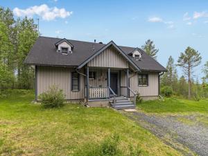 una pequeña casa con porche en el césped en Holiday Home Mustikka by Interhome en Kuusamo