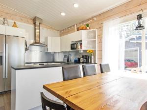 - une cuisine avec une table et des chaises en bois dans l'établissement Holiday Home Metsäpirtti by Interhome, à Keuruu