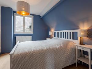 a blue bedroom with a bed and a window at Holiday Home La Normande by Interhome in Touques