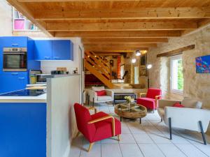 une cuisine et un salon avec des armoires bleues et des fauteuils rouges dans l'établissement Holiday Home La Torche by Interhome, à Plovan