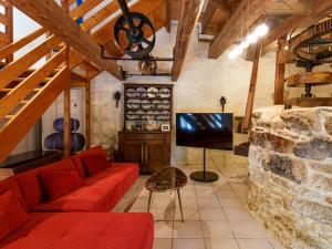 - un salon avec un canapé rouge et une télévision dans l'établissement Holiday Home La Torche by Interhome, à Plovan