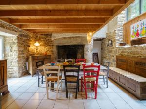 une salle à manger avec une table, des chaises et une cheminée dans l'établissement Holiday Home La Torche by Interhome, à Plovan