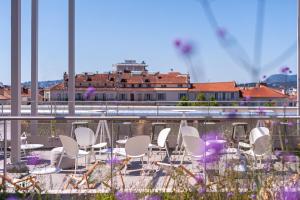 - un ensemble de chaises blanches assises sur un balcon dans l'établissement Hostel Le Hüb Toulon, à Toulon