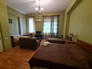 Habitación de hotel con 2 camas y sofá en Piano Hotel en Tiflis