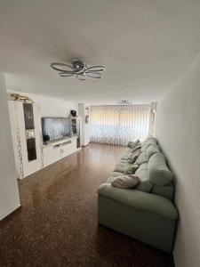 een woonkamer met een bank en een plafondventilator bij Vacaciones Premium in Burriana