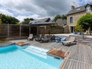 einen Pool mit einer Terrasse und einem Sonnenschirm in der Unterkunft Holiday Home La Gentilhommière by Interhome in Le Tronchet