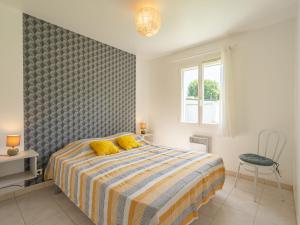 a bedroom with a bed with yellow pillows at Holiday Home Villa Margarin by Interhome in Les Mathes
