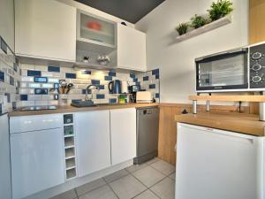 uma cozinha com armários brancos e um micro-ondas em Apartment Horizon by Interhome em Saint-Pierre-dʼOléron