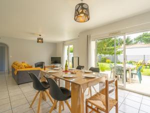 een eetkamer en een woonkamer met een tafel en stoelen bij Holiday Home Villa Margarin by Interhome in Les Mathes