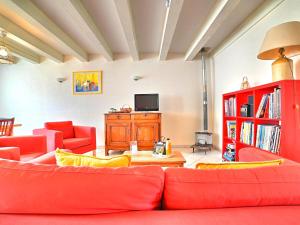 een woonkamer met rode meubels en een televisie bij Holiday Home Matha by Interhome in Saint-Pierre-dʼOléron