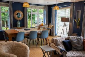 a living room with a dining room table with blue walls at Maes Yr Haf in Swansea