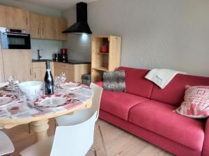 uma sala de estar com um sofá vermelho e uma mesa em Studio Les Tétras by Interhome em Saint-Gervais-les-Bains