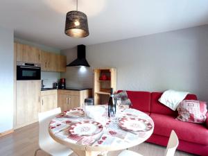 uma sala de estar com uma mesa e um sofá vermelho em Studio Les Tétras by Interhome em Saint-Gervais-les-Bains