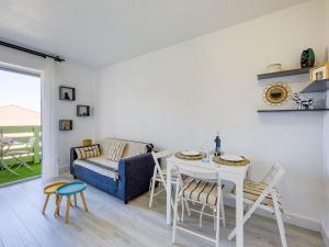 a living room with a table and chairs and a couch at Apartment Les Pins by Interhome in Narbonne-Plage