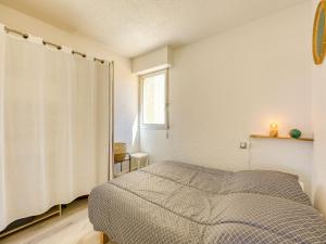 a bedroom with a bed and a window at Apartment Les Pins by Interhome in Narbonne-Plage