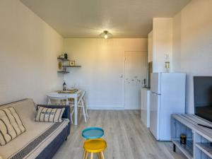 a living room with a couch and a refrigerator at Apartment Les Pins by Interhome in Narbonne-Plage