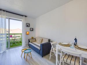 a living room with a couch and a table at Apartment Les Pins by Interhome in Narbonne-Plage +17 photos