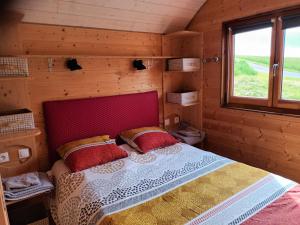 ein Schlafzimmer mit einem Bett in einer Holzhütte in der Unterkunft La roulotte du tonnelier in Castelnau-de-Montmiral