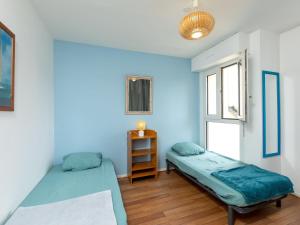 2 camas en una habitación con paredes azules en Apartment Saint Sieu by Interhome en Lancieux