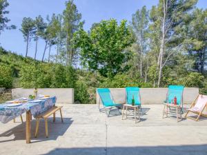 eine Terrasse mit 2 Stühlen, einem Tisch und 2 blauen Stühlen in der Unterkunft Villa la familiale by Interhome in La Madrague