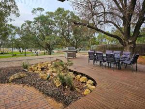 a patio with chairs and a table and a grill at Riverview Haven in Waikerie