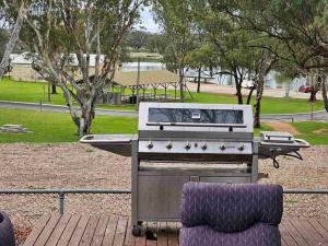 een barbecue op een terras met een park bij Riverview Haven in Waikerie