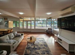 een woonkamer met een bank, een tafel en een tv bij Riverview Haven in Waikerie
