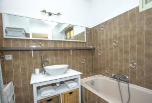 een badkamer met een wastafel, een bad en een spiegel bij Spacieux appartement de 70 m2, 2 chambres, au calme proche du Vieil Antibes in Antibes