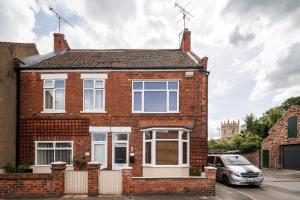 a red brick house with a car parked in front at Free Parking Stylish House Near Humber Bridge in Barton-upon-Humber