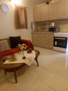 a living room with a couch and a table at Angela's Cute Apartment (A/C, WiFi, Little Garden) in Análipsis