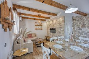 a kitchen and living room with a table and chairs at Casa Darel with Whirlpool in Vižinada