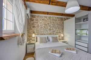 a bedroom with a bed and a stone wall at Casa Darel with Whirlpool in Vižinada
