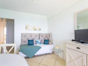 Habitación blanca con sofá y TV en Apartment La Galiote-2 by Interhome en Le Lavandou