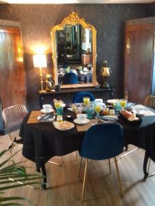 a table with food and a mirror in a room at La Ménardière "Tranquilitatis" Chambre double petit déjeuner compris in Corseul