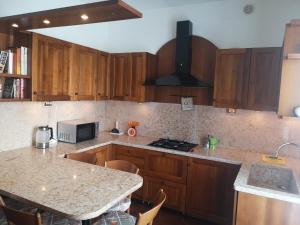 een keuken met houten kasten en een aanrechtblad bij Ai Quattro Ulivi in Peschiera del Garda