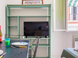 een boekenplank met een tv en een tafel bij Studio Helder by Interhome in Biarritz