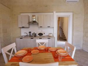 eine Küche mit einem Holztisch mit Tellern darauf in der Unterkunft Apartment Spicchi di Salento-2 by Interhome in Vernole