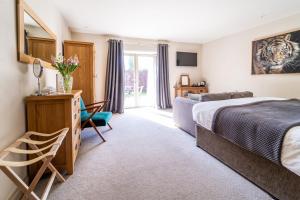 ein Hotelzimmer mit einem Bett und einem Schreibtisch mit einem Spiegel in der Unterkunft The Honingham Buck in Norwich