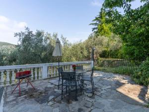 a patio with a table and chairs and an umbrella at Apartment Mimosa by Interhome in Gazzelli