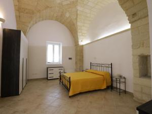 een slaapkamer met een geel bed in een witte kamer bij Apartment Spicchi di Salento-1 by Interhome in Vernole