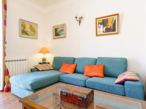 a living room with a blue couch with orange pillows at Apartment Maison Simonne by Interhome in Biarritz