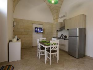 a kitchen with a table and chairs and a refrigerator at Apartment Spicchi di Salento-3 by Interhome in Vernole