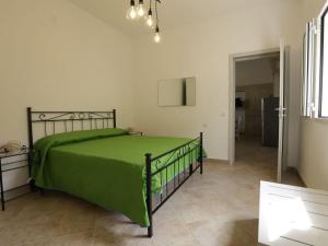 1 dormitorio con 1 cama con colcha verde en Apartment Spicchi di Salento-3 by Interhome, en Vernole