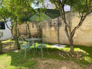 a table and chairs under an umbrella in a yard at Apartment Spicchi di Salento-3 by Interhome in Vernole