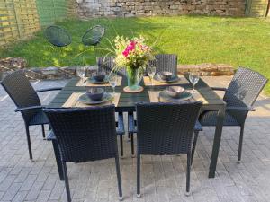 una mesa negra con sillas y un jarrón de flores en Landidylle im Erlbachtal, en Kraftsdorf
