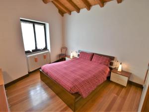 a bedroom with a bed with a red blanket and a window at Apartment Isola di Madesimo Apartments-3 by Interhome in Isola