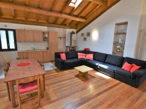 a living room with a black couch and a table at Apartment Isola di Madesimo Apartments-3 by Interhome in Isola