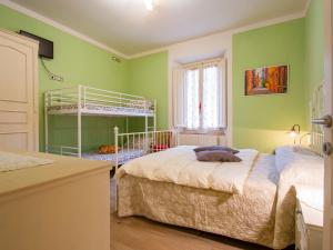 1 dormitorio con 2 camas y paredes verdes en Apartment Matteo by Interhome, en Avaglio